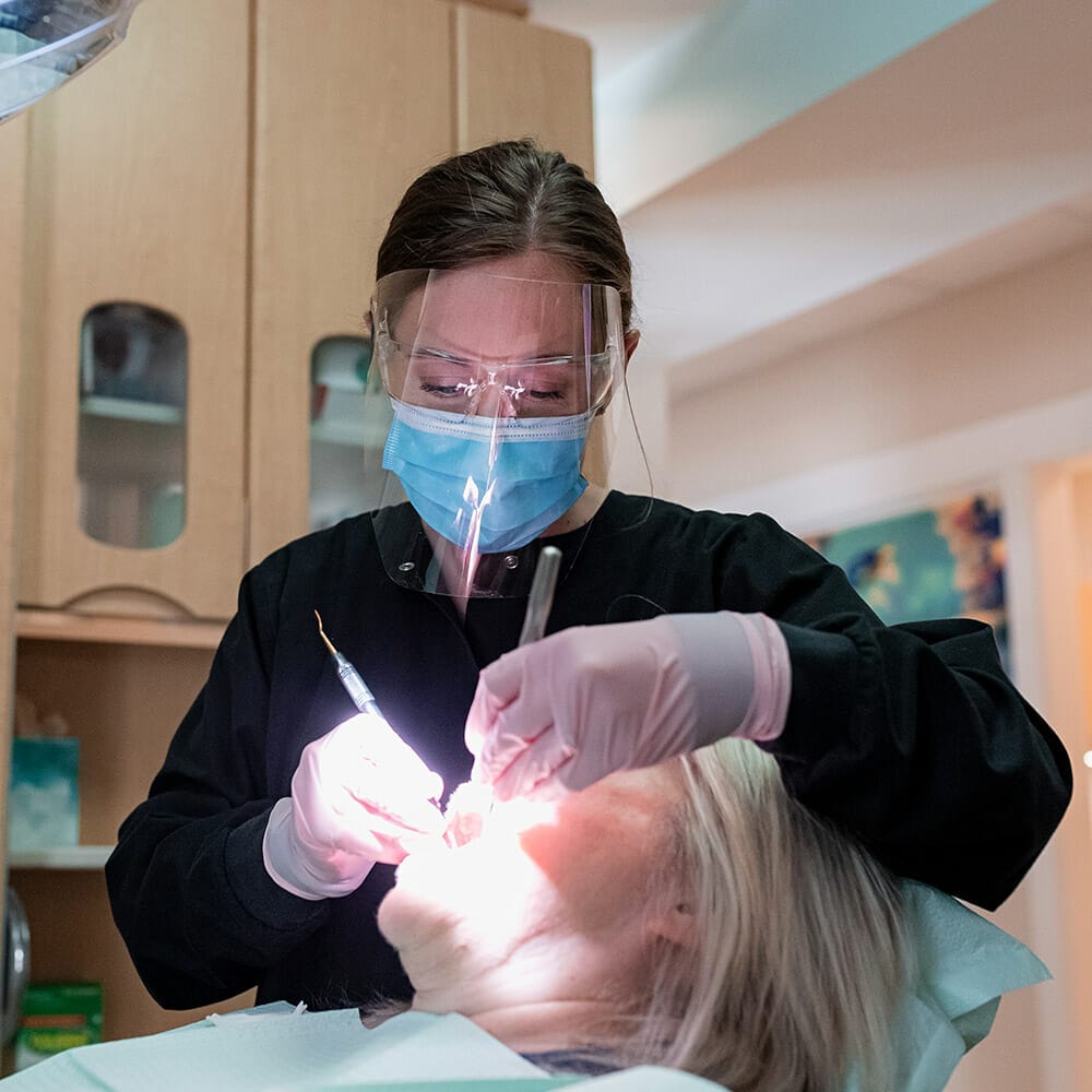 patient in chair getting teeth cleaned before dental sealants are applied