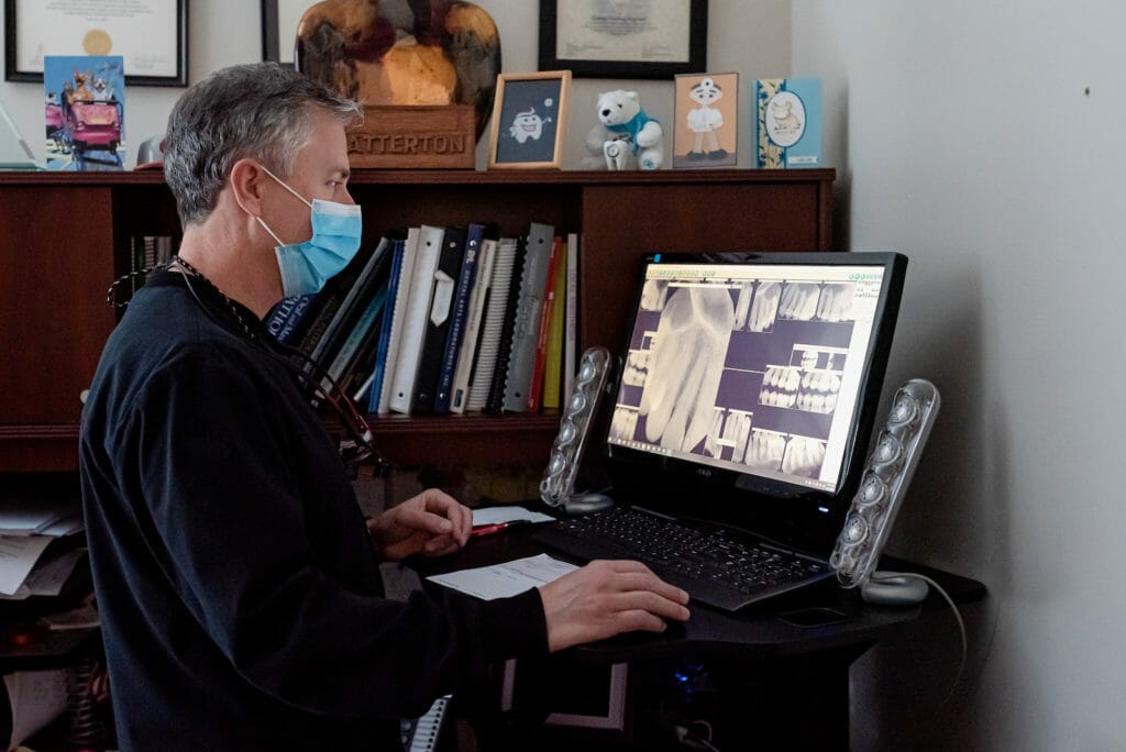 Dr. Eric Batterton evaluating patient x-rays at standing desk