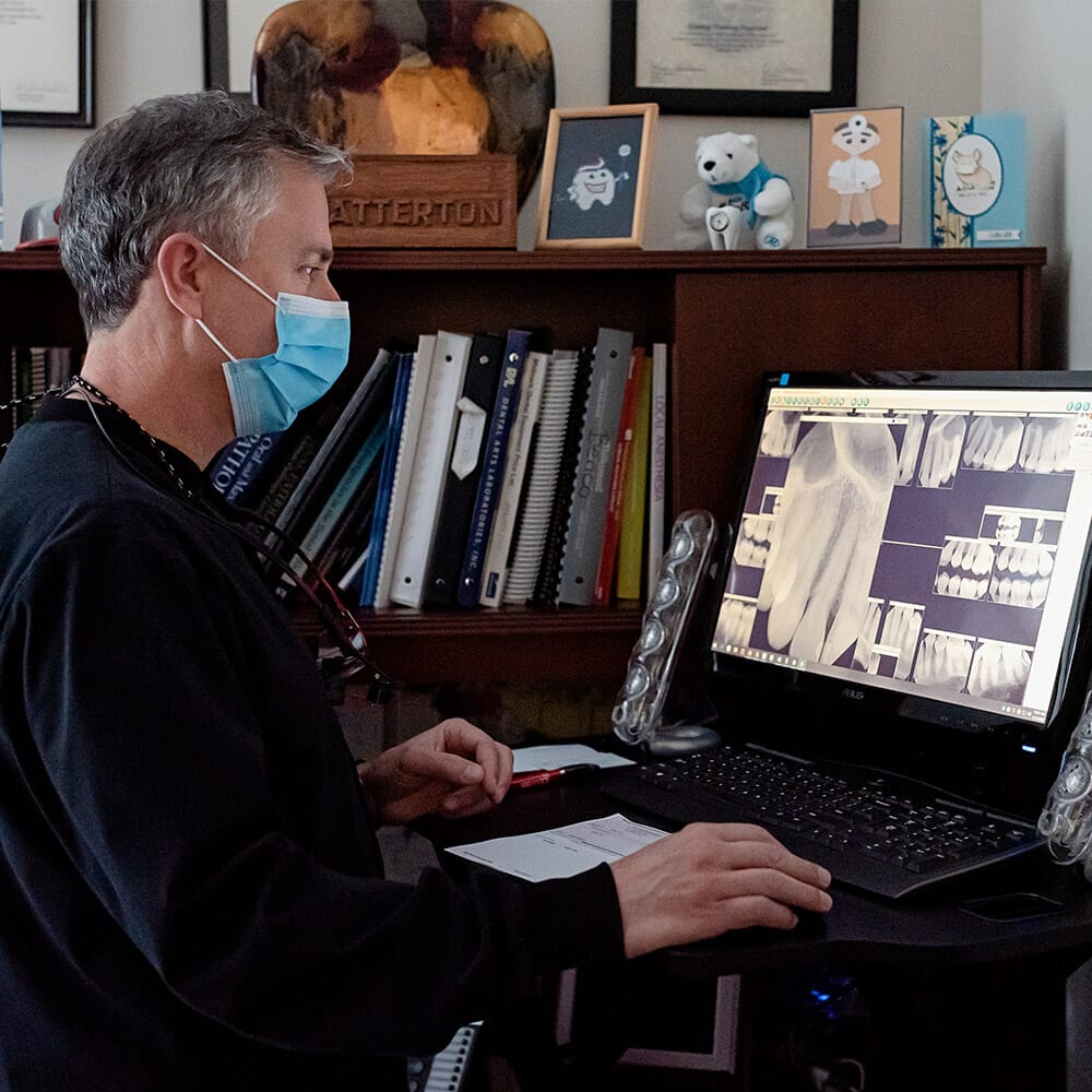 Dr. Batterton evaluating patient x-rays before denture fitting