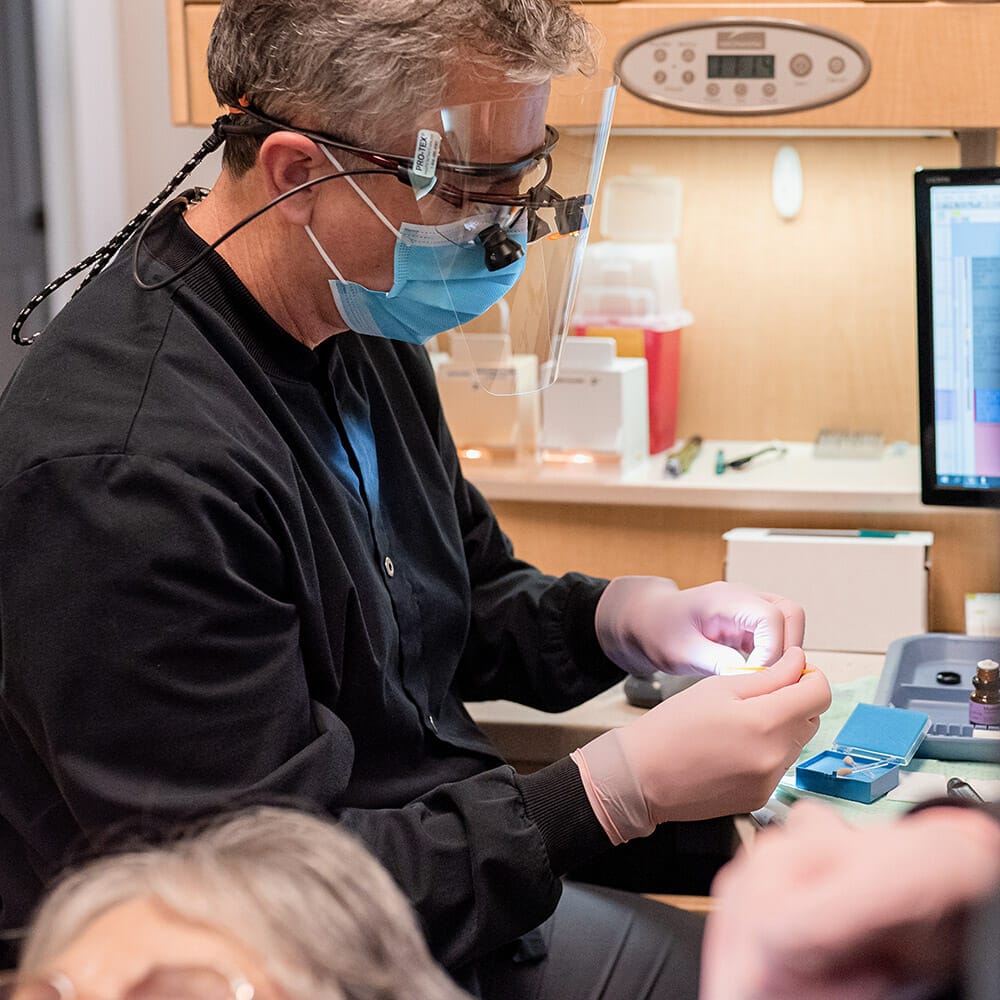 Dr. Batterton inspecting dental crown before placement