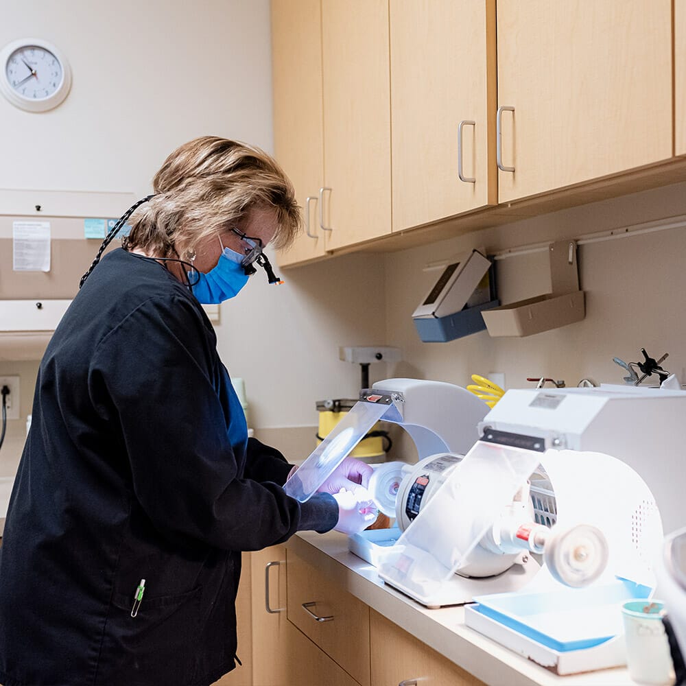 Team member in lab working on dental fixture before placement