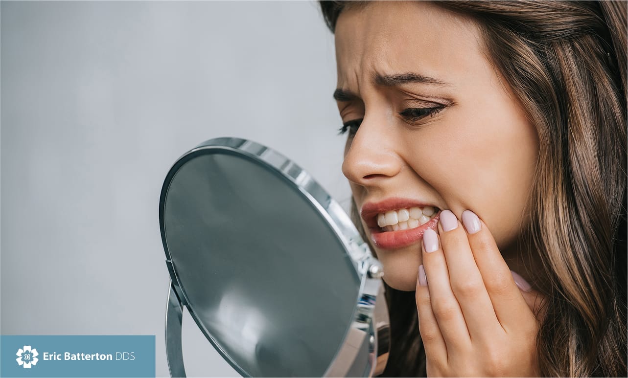 woman having teeth discomfort checking mirror