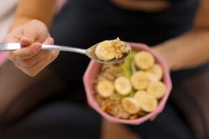 Close-up of spoon in bowl with banana slices and cereal.