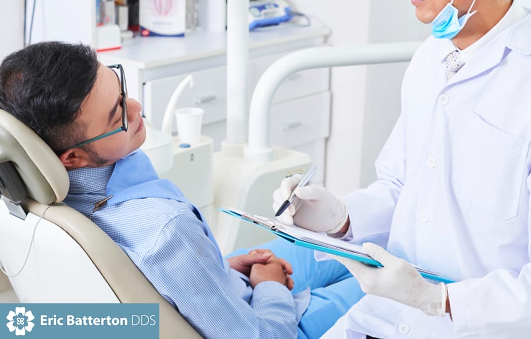 Man lying down during dental checkup with dentist checklist